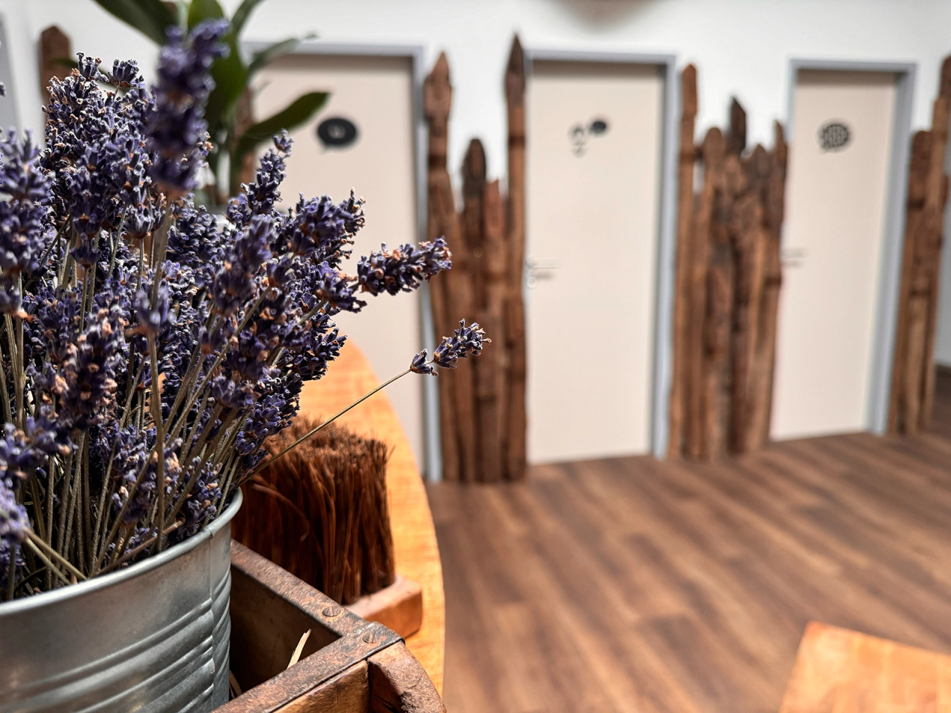 Modernes Wohnzimmer mit massiver Holzkommode, gemütlicher Sitzgruppe, grünen Pflanzen und warmem, skandinavisch-moderner Ambiente