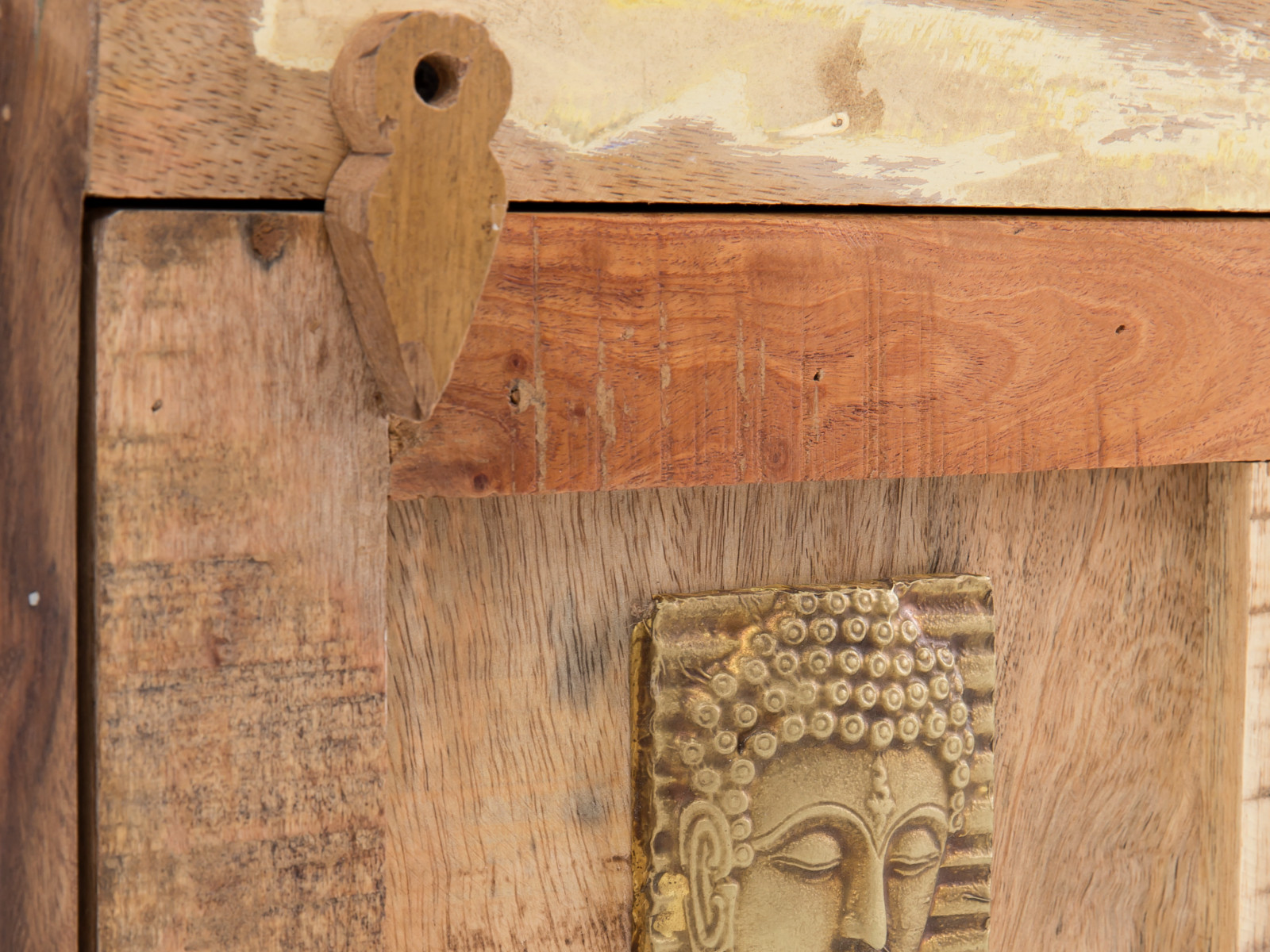 Detailansicht des Eckhochschranks Sumana: lackierte Front aus recyceltem Hartholz in Braun mit goldfarbenem Buddha-Relief.