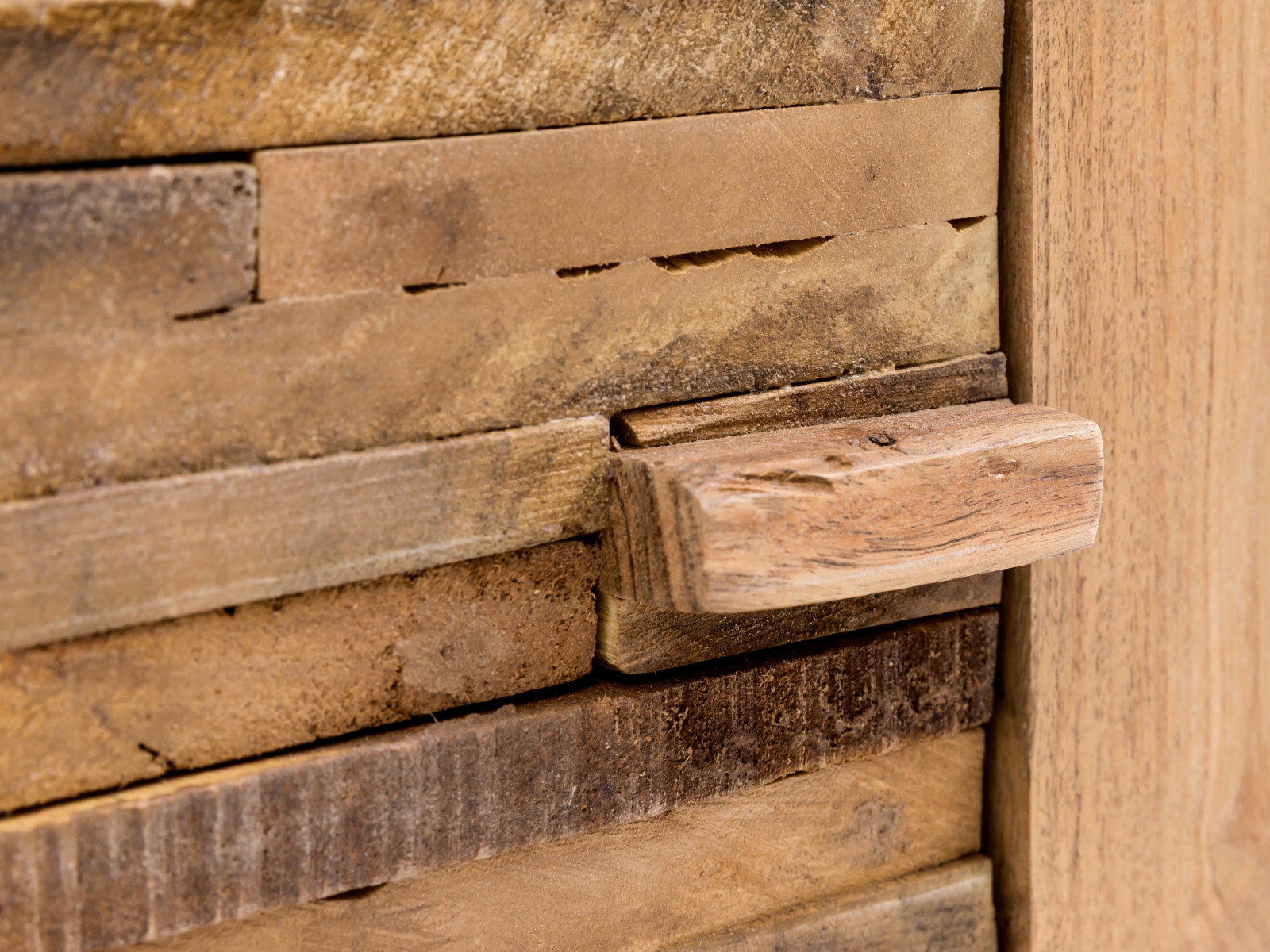 Detailansicht des lackierten Akazienholz-Türgriffs am naturfarbenen Hängeschrank Matay