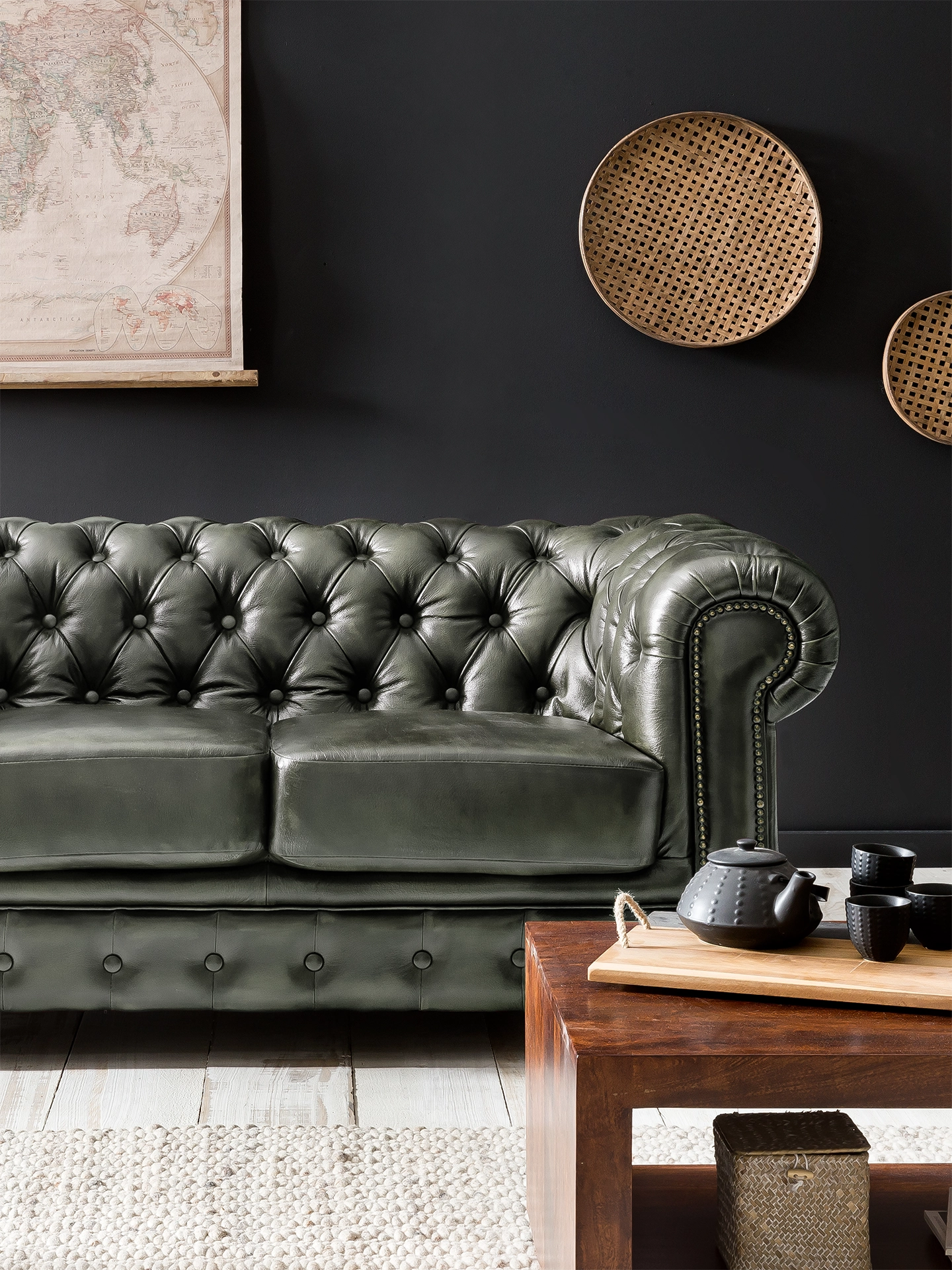 Hoher Chesterfield-Sessel mit klassischer Knopfheftung und gerollten Armlehnen in stilvollem Ambiente