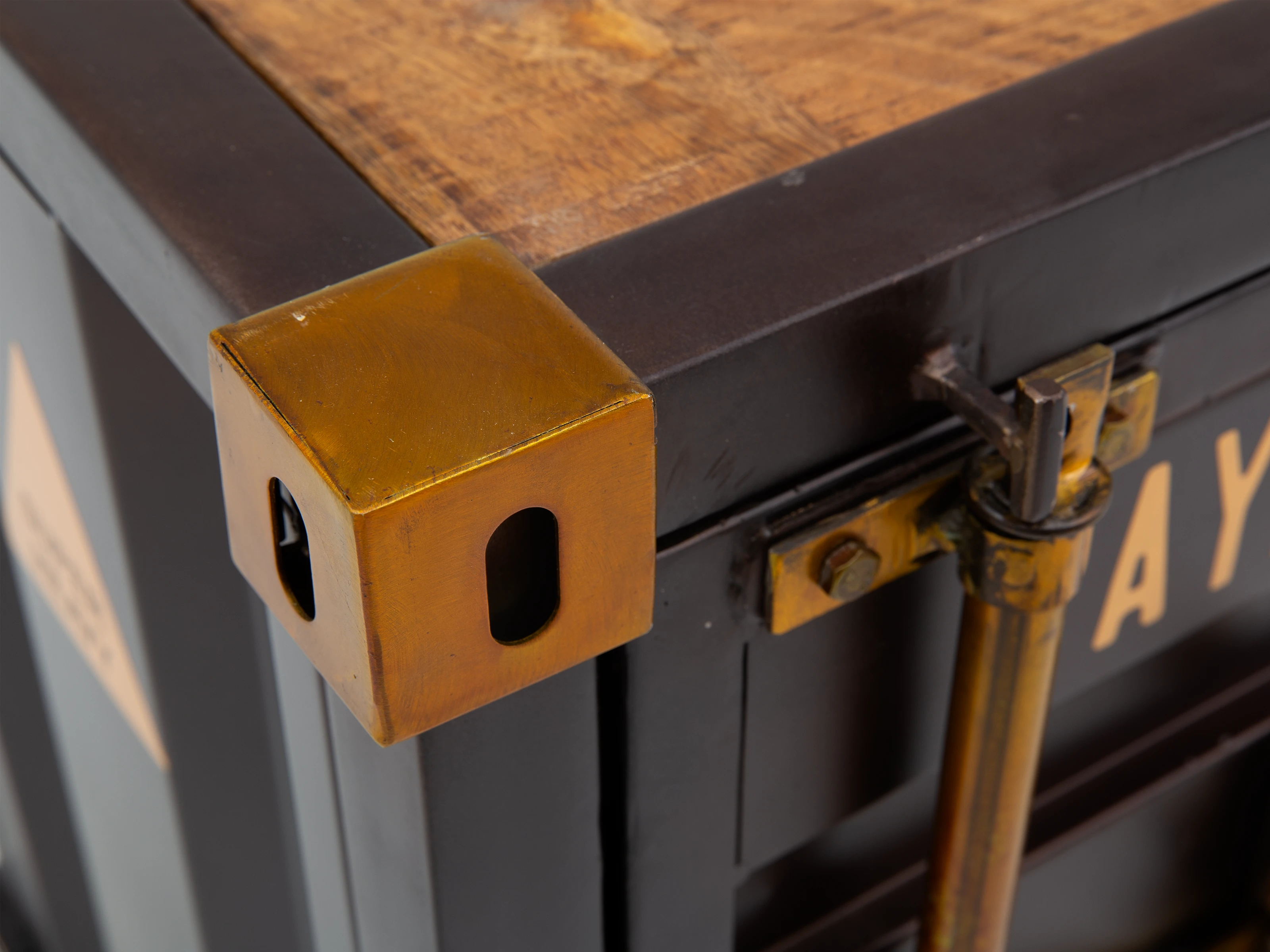 Beistelltisch Cargon Detail (45°): lackierte Mango-Holzplatte mit braunem Metall-Eckschutz und Türverschluss